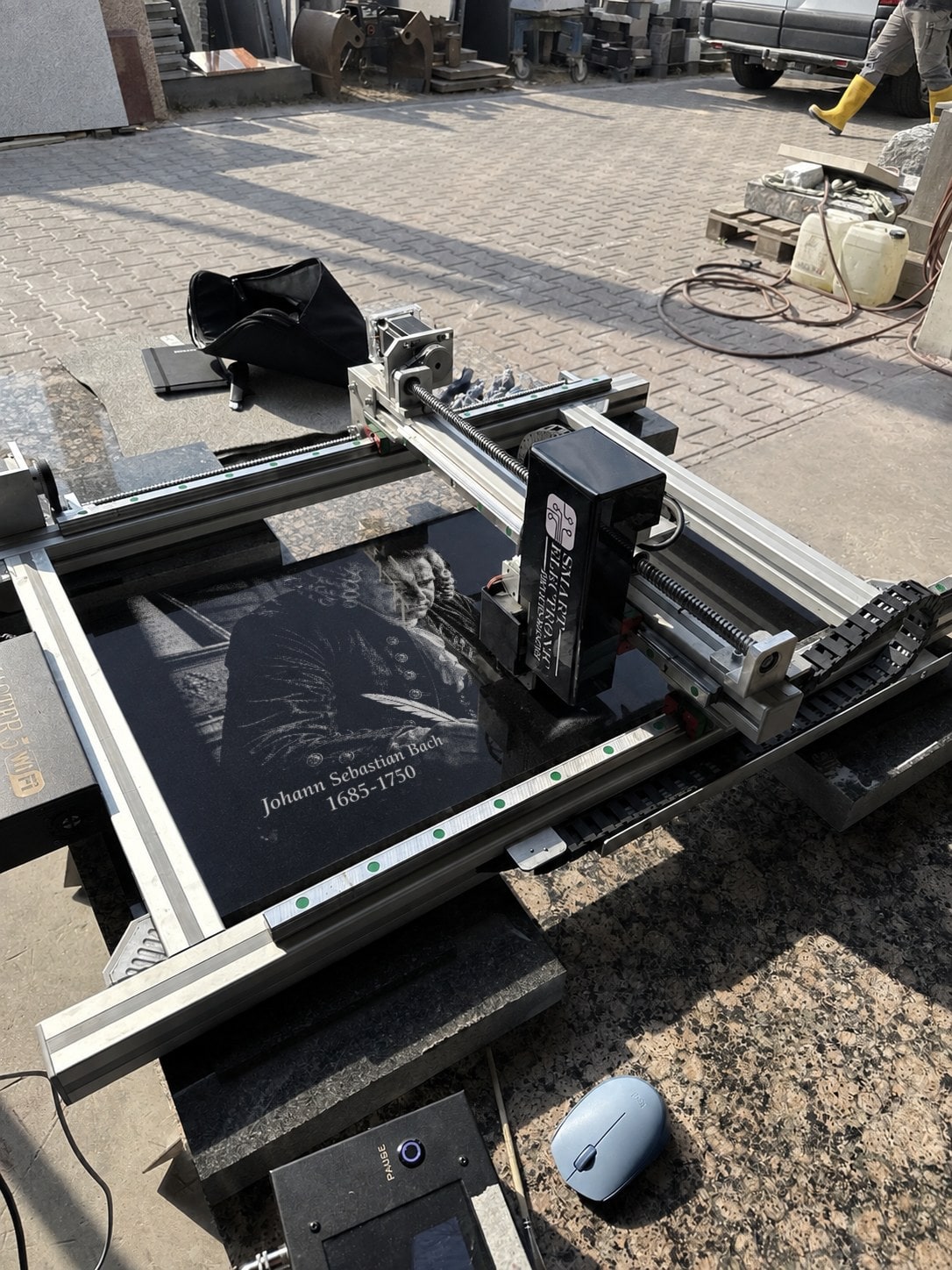 CNC-Graviermaschine graviert ein Porträt direkt auf der Granitplatte in der Werkstatt des Kunden